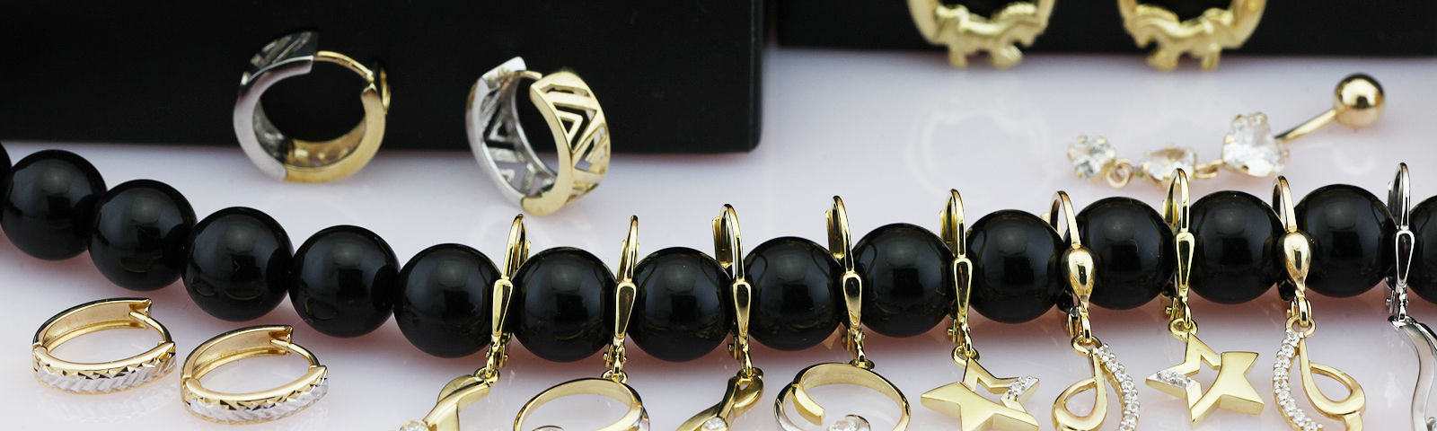Gold ear jewelry on black pearl necklace